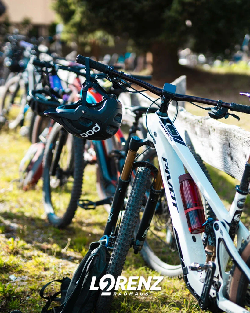 Nahaufnahme von Mountainbike-Lenkern, an denen ein schwarzer Helm hängt.