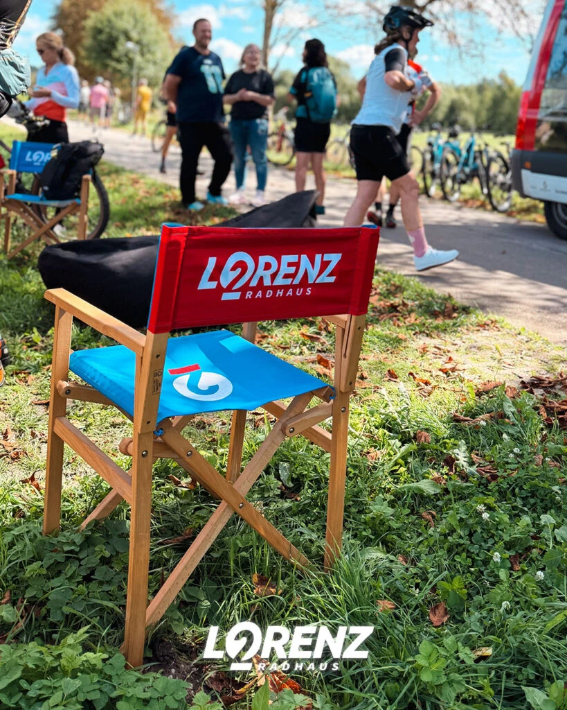 Ein roter Regiestuhl mit dem Logo von Lorenz Radhaus steht auf einer Wiese.